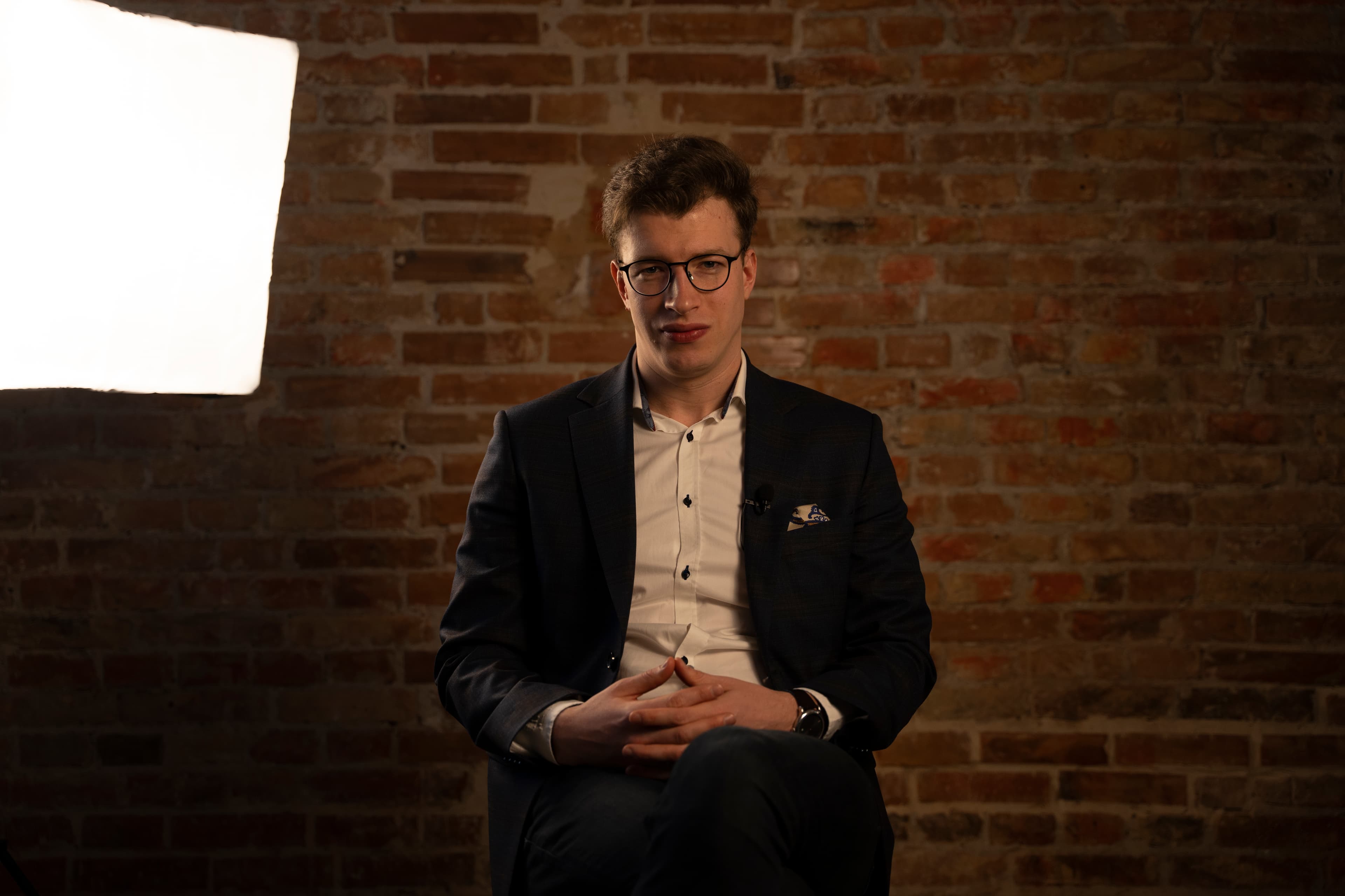 Roman Saienko podczas nagrania w studiu na tle ceglanej ściany